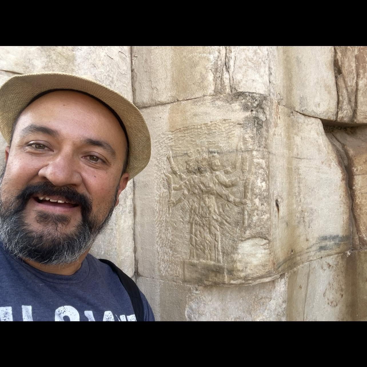 Jorge Quiñones beside an ancient carved stone artifact